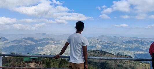Back-view Portrait of Traveler Overlooking Scenic Hillside