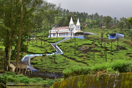 Karumalai Velankanni Church surrounded by misty tea estates and rolling hills in Valparai, showcasing peaceful countryside and nature beauty