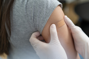 People getting a vaccination to prevent pandemic concept. Woman in medical face mask  receiving a dose of immunization coronavirus vaccine from a nurse at the medical center hospital