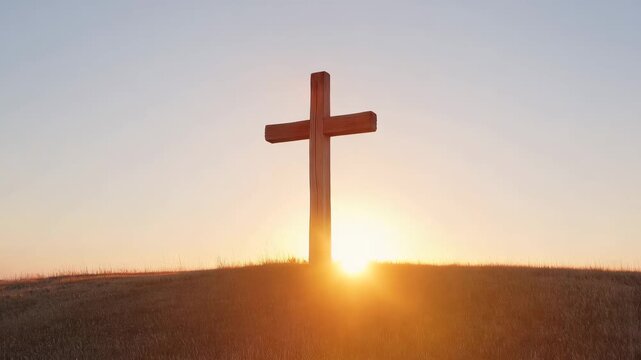 Wooden cross on a hill silhouetted against a sunrise or sunset, symbolizing hope and belief for christianity.