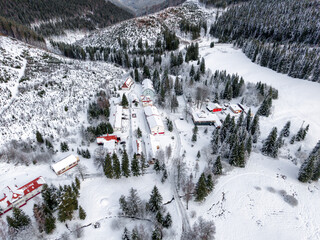 Aerial winter view of small ski resort Zelezno near Liptovska Luzna with snowy slopes forest and ski lift