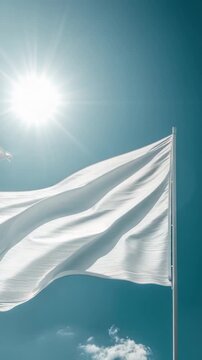 A white flag waving gently in the breeze on a bright and sunny day, great for representing surrender or truce
