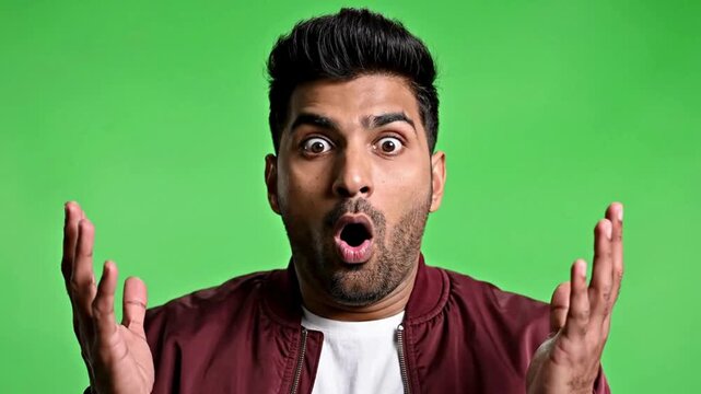 Surprised man in maroon jacket with shocked expression on green background in studio lighting for advertising HD & 4K stock video Royalty-free footage Best trending