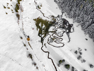 Top down aerial view of Luznanka river meander in snowy landscape near Liptovska Luzna