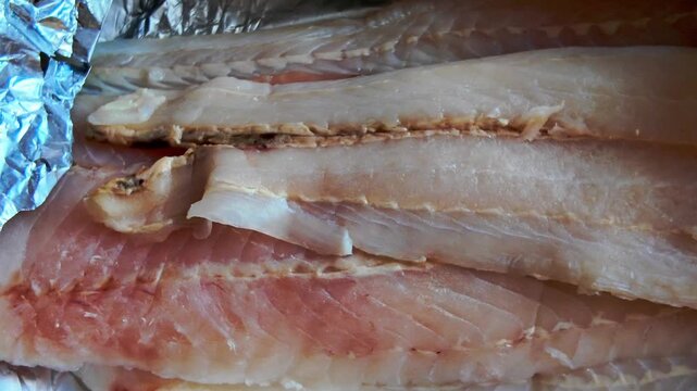 Presentation of raw fish fillets on aluminum foil, fresh seafood meat prepared for cooking process