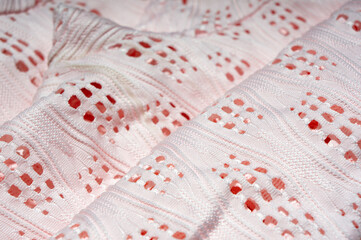 Close-up of patterned white fabric with holes