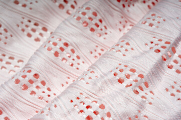 Close-up of patterned white fabric with holes