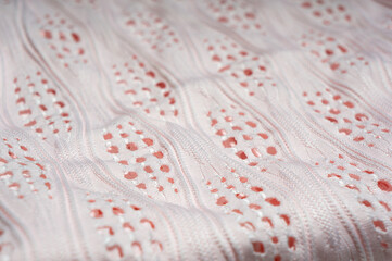 Close-up of patterned white fabric with holes