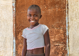 Happy African girl in rural Botswana village. Authentic humanitarian portrait for aid, charity, and...