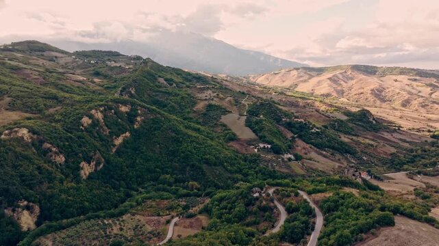 Aerial footage of mountain landscapes near Roccascalegna with vineyards, pastures and muted sunset light.