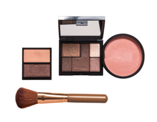 Makeup eye shadows, blush and brush on black backdrop