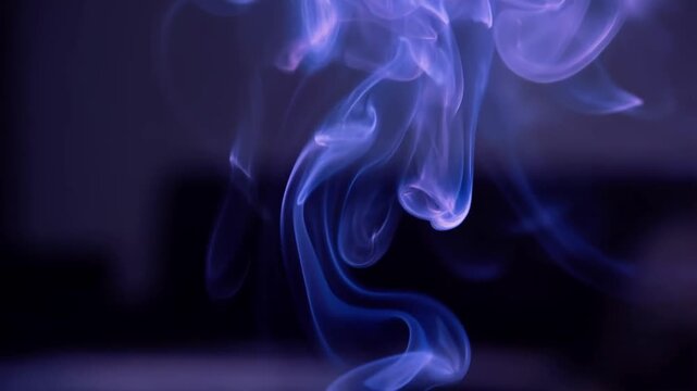 Abstract curling smoke wisps in blue and purple duotone on dark background, smooth loop video footage