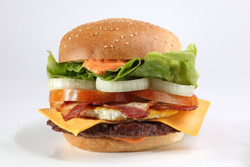 Close up of an hamburger with bacon, lettuce, onion cheese and egg