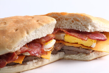 Close up of a beef sandwich with bacon cheese and egg