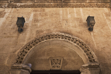 Close-up view of ornate stone arch with carved decorative details on historic building facade