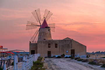 Sunset at the salt flats with the old windmill, saline dello Stagnone. Marsala, Trapani, Sicily,...