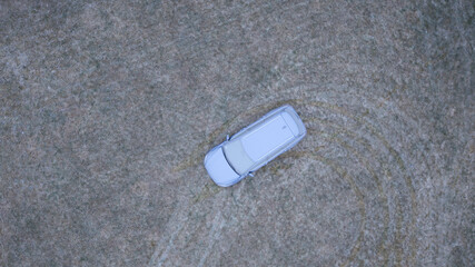 Aerial View of a Frost-Covered Car on Frozen Grass During an Icy Winter Morning.