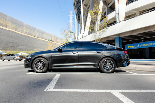 October 27, 2021, Seoul, South Korea - A dark gray Kia K5 sedan parked in an outdoor parking lot on a sunny day.