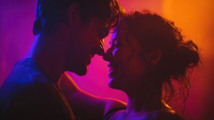 Close-up of a joyful couple touching foreheads under vibrant purple and orange lighting creating an intimate playful moment of modern romance