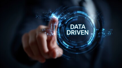 A person in a formal suit touches a glowing virtual interface with the text "DATA DRIVEN" surrounded by digital circuits