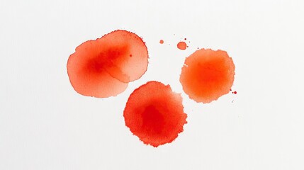 Three red watercolor stains on a white background. The shapes are irregular and vary in size, creating a simple yet artistic composition.