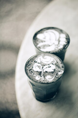 Two activated charcoal lattes. Goth black trendy latte