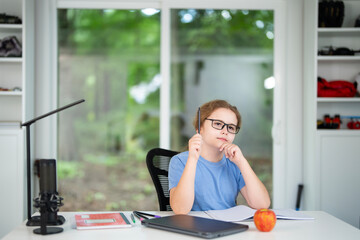 Child on online school lesson at home. Kid learning on laptop e-learning. Teen student learn lesson on laptop. Teenager study remotely using laptop. Teen student doing homework during online lesson.