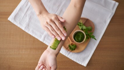 Natural skincare routine woman applying herbal remedy at home with calming light and texture detail