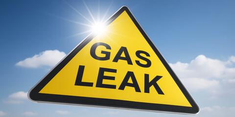 Yellow triangular warning sign with GAS LEAK text, signaling danger and environmental hazard against a blue sky