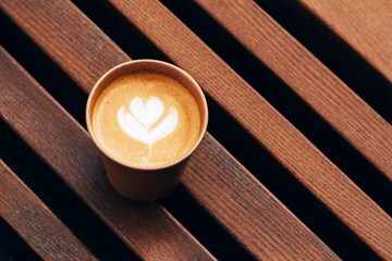 Paper cup of Coffee take-away, top view. Wooden table and place for text.