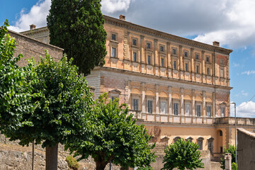Italy - Caprarola - Palazzo Farnese - Side facade of the Renaissance palace with trees and cloudy sky