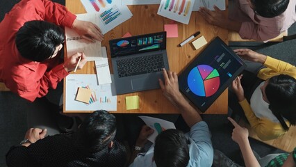 Top view of business team working together while talking about financial chart. Close up of skilled marketing team sharing idea and looking at stock market statistic chart at boardroom. Convocation.