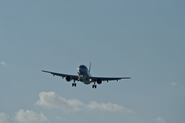 Silhouette of Commercial Airplane Approaching Runway for Landing Against Clear Blue Evening Sky