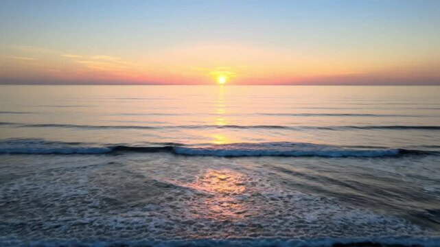 Calm Ocean Waves at Sunrise with Golden Light Reflection