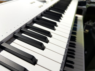 Piano keyboard synthesizer electronic music instrument studio. Modern synthesizer keyboard with white and black notes. Synthesizer keyboard, offering detailed perspective of its keys and controls