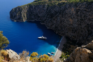 Fototapeta premium Aerial view of Butterfly Valley, also known as Kelebekler Vadisi, a natural canyon and beach with its crsytal clear turquoise waters on the Mediterranean coast near Ölüdeniz in Fethiye, Turkey