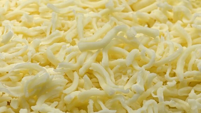 Grated mozzarella texture. Shredded cheese close-up, cooking with dairy product. Pizza or pasta ingredient, food background