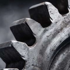 Close up of heavy duty metal gear teeth with surface wear and minor damage for industrial machinery failure analysis.