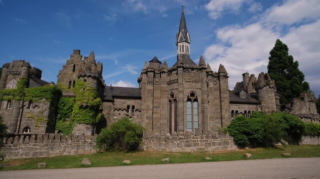 Stone Castle Gate Cobblestone Path Dappled Sunlight, Ancient Fortress Entrance Framed By Leafy Tree, Warm Summer Sky, Deep Shadow Contrast, Worn Brick Textures, Inviting Archway. Kassel, Germany.