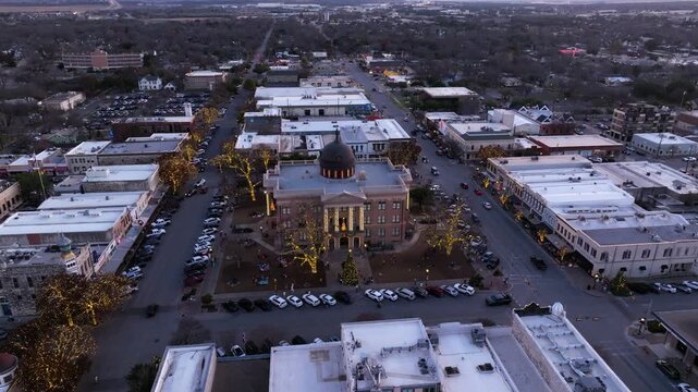 Aerial slow drone movement towards Christmas lights surround the Williamson County Courthouse in downtown Georgetown in Texas in late December 2025