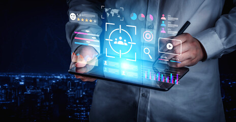A professional interacts with a tablet showcasing dynamic digital elements for data analysis and audience targeting against a stunning night city backdrop. Gantry
