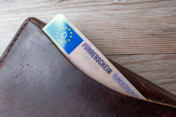 German driver's license with EU flag in brown leather wallet, Modern European driving permit, transport rights, EU citizen travel, Germany mobility document, close-up macro shot