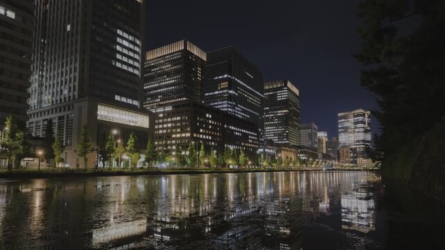 "Night view of Babasaki Moat between Tokyo Station and Imperial Palace &ndash; HDR (PQ) timelapse with city reflections"