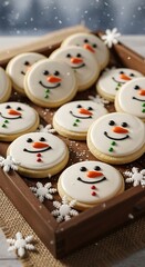 A wooden tray is filled with snowman-shaped cookies with white icing, orange carrot noses, and smiling faces. Snowflakes are scattered