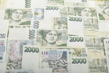 Overhead shot showcasing a collection of Czech Koruna banknotes, primarily featuring denominations of 2000 and 5000 CZK, arranged to display their designs and monetary value, Czech Republic.