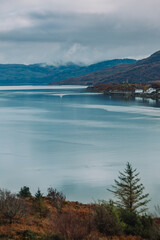 Beautiful Traditional Cottages and Lighthouse on Eilean B&agrave;n Island, Isle of Skye, on a Sunny Winter Morning. as seen from the Skye Bridge