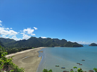 High angle view of a curved bay with low tide sand flats and forested hills