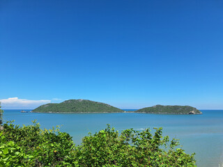 Two green tropical islands floating in a calm blue ocean