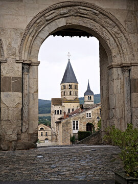 Cluny Abbey in France photographed through stone arch, medieval architecture, historic monastery, cultural heritage landmark in Burgundy