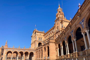 Fototapeta premium The iconic Spain Square showcases grand architecture, tiled bridges, and a vibrant urban atmosphere in Sevilla, Spain.